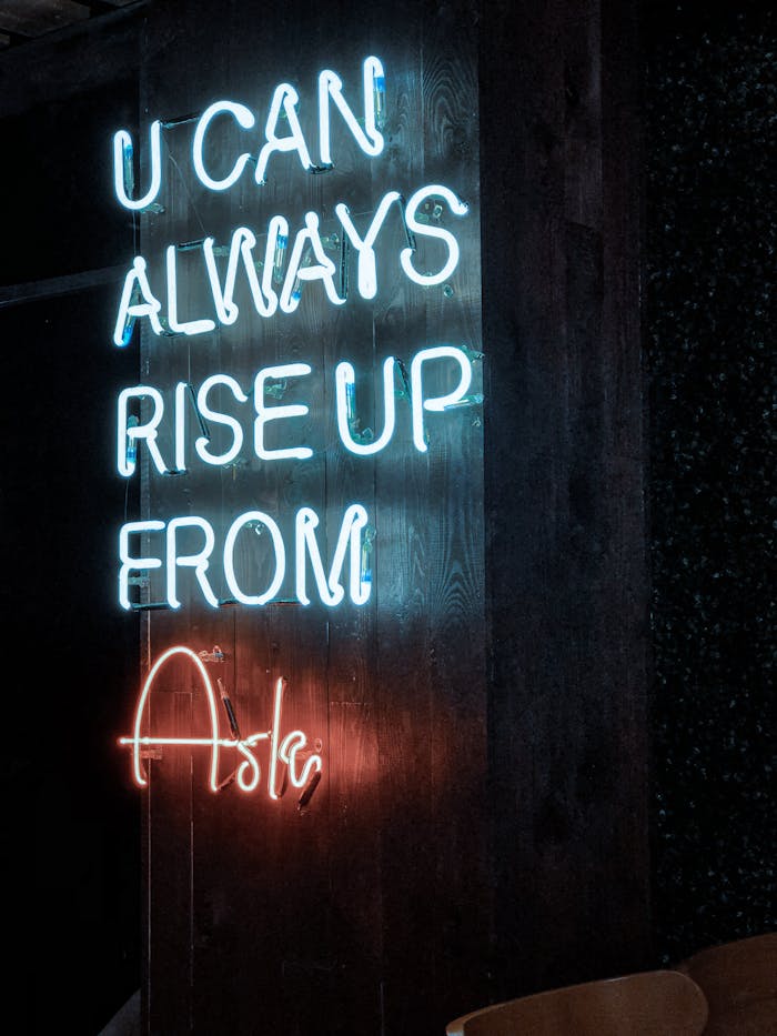 services-03 Neon sign stating 'U CAN ALWAYS RISE UP FROM ASHES' on a dark background, glowing brightly.